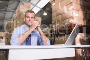 Portrait of warehouse manager with laptop