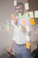 Casual businessman looking at sticky notes