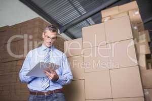 Manager with clipboard in warehouse