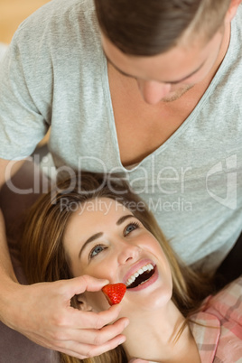 Man feeding his girlfriend a strawberry