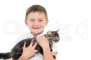 Little boy holding grey kitten smiling at camera