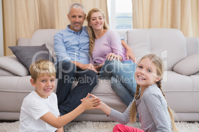 Happy parents with their children on floor