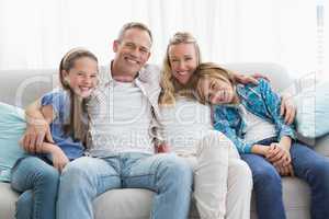 Parents and children sitting together on couch