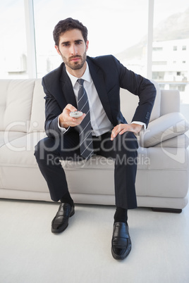 Businessman holding a tv remote