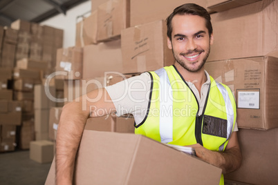 Worker carrying box in warehouse