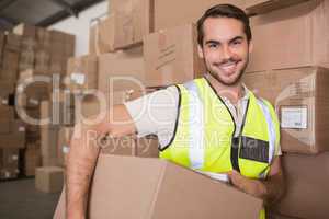 Worker carrying box in warehouse