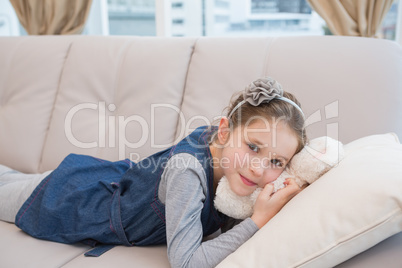 Little girl lying on the couch with teddy