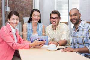 Smiling business people working on tablet pc