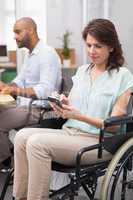 Businesswoman in wheelchair texting on phone