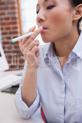 Casual businesswoman smoking an electronic cigarette