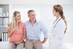Happy couple talking to doctor