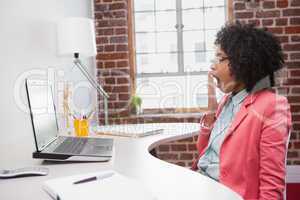 Tired casual businesswoman sitting at desk