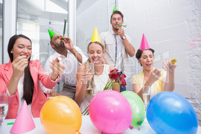 Business team celebrating with champagne and party horns