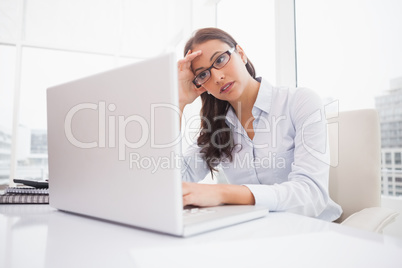 Focused businesswoman using laptop at desk