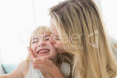 Mother kissing happy daughter on the cheek