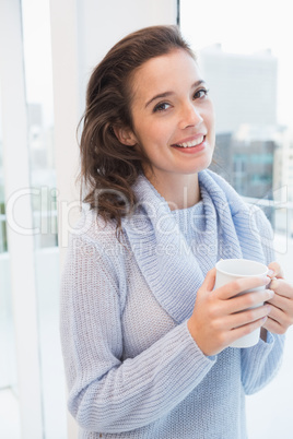 Pretty brunette having coffee by the window