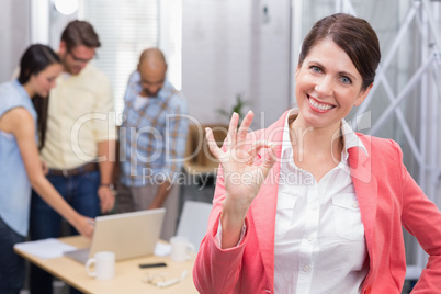 Happy businesswoman making okay gesture