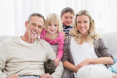 Happy family sitting with pet kitten together