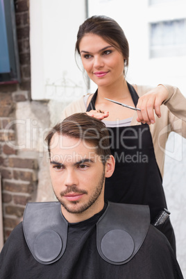 Handsome man getting his hair trimmed