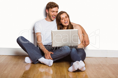 Young couple using laptop on floor