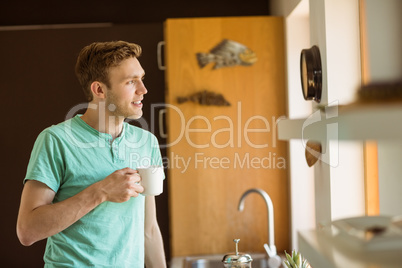 Young man smiling and holding coffee