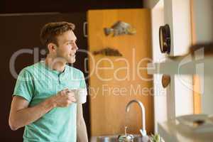 Young man smiling and holding coffee