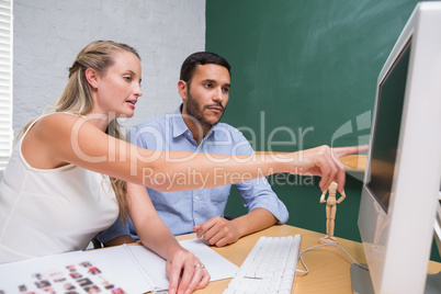 Casual young colleagues using computer at office