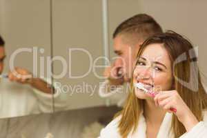 Cute couple brushing their teeth