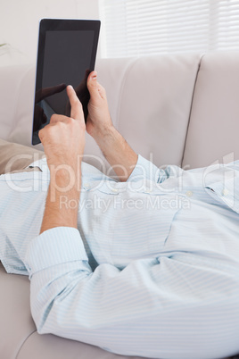 Casual man using tablet on the couch