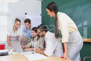 Casual business team having a meeting using laptop