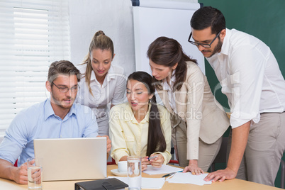 Casual business team having a meeting using laptop