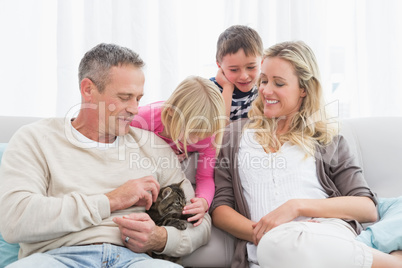 Happy family sitting with pet kitten together