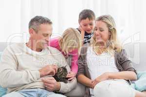 Happy family sitting with pet kitten together