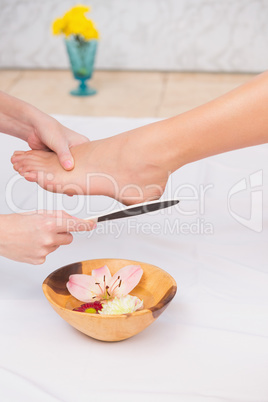 Woman getting a pedicure from beautician