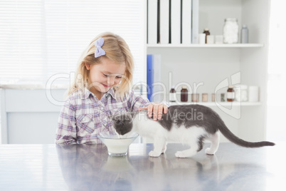 Happy owner petting her cat drinking milk