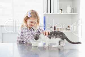 Happy owner petting her cat drinking milk
