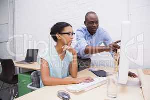 Man showing something to his colleague on the laptop