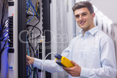 Technician smiling at camera while fixing server