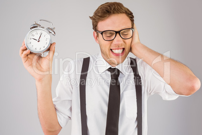 Geeky businessman holding alarm clock