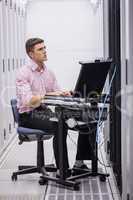 Technician sitting on swivel chair using laptop to diagnose serv