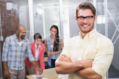 Businessman smiling at camera with arms crosse