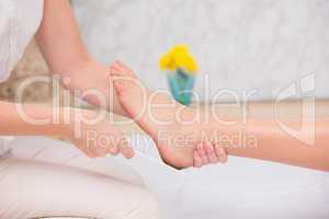 Woman getting a pedicure from beautician