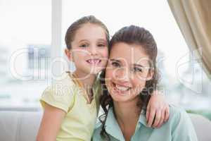 Cute mother and daughter smiling at camera