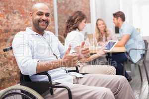 Man in wheelchair smiling at camera giving thumbs up