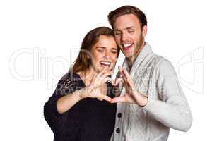 Happy couple forming heart with hands