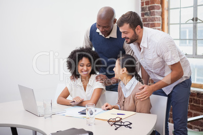 Casual business team having a meeting using laptop