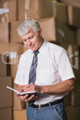 Manager with diary in warehouse