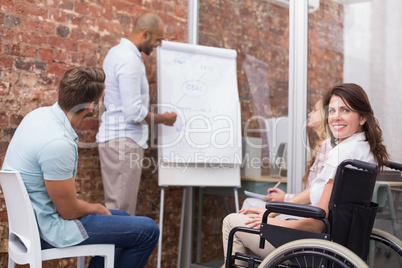 Woman in wheelchair smiling at camera during presentation