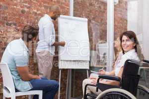 Woman in wheelchair smiling at camera during presentation