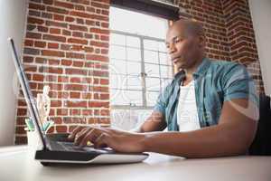 Casual businessman working on laptop at desk